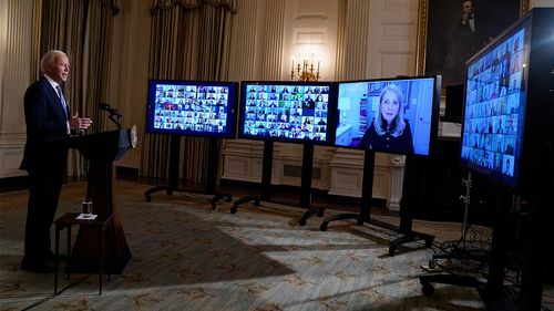 President Joe Biden listens during a virtual swearing in ceremony of political appointees from the State Dining Room of the White House.