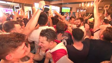 England football fans celebrate in the streets after victory over Sweden