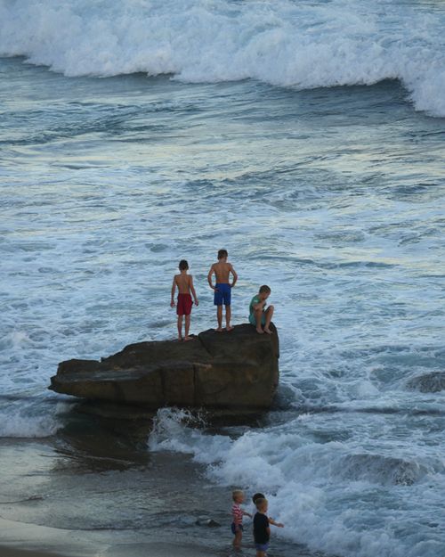 Children play near the shore as residents of Newcastle, New South Wales, look for alternative ways to beat the heat as beaches are closed for a seventh consecutive day in January 16, 2015 due to shark sightings at popular beaches. (AAP)