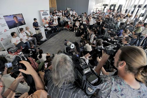 A packed media scrum listen to representatives from various NGOs after the migrant arrived. Picture: AP