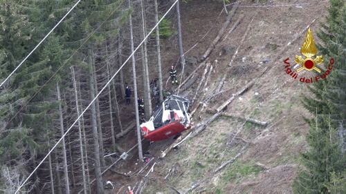 Rescuers worked by the wreckage of a cable car after it collapsed near the summit of the Stresa-Mottarone line in the Piedmont region, northern Italy. 