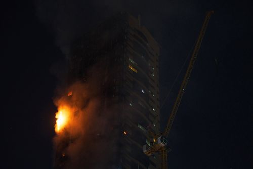 A fire burns on the side of a high-rise building in Sharjah, United Arab Emirates