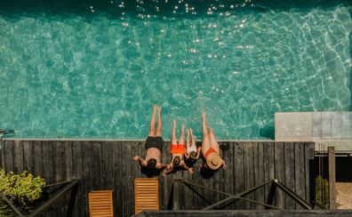 Photo of a young family with two children, relaxing by the pool in a vacation rental villa