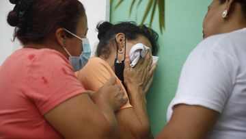 Relatives of inmates wait in distress outside the entrance to the women&#x27;s prison in Tamara, on the outskirts of Tegucigalpa, Honduras, Tuesday, June 20, 2023.
