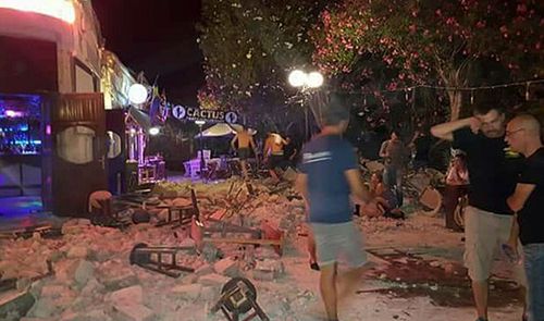 Tourists outside a bar take stock of the quake damage on Kos. (Photo: AP).