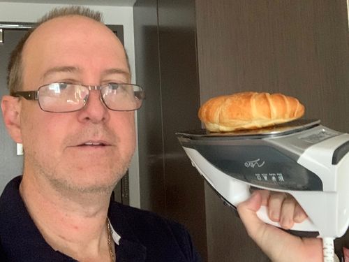 The Sydney dad heats up a croissant on an iron, while he is stuck in quarantine.