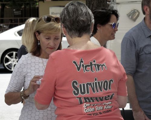 Jane Carson-Sandler, of South Carolina, who was raped by the so-called Golden State Killer in 1976, wears a t-shirt with a message to her attacker in Sacramento, Calif., Thursday, July 12, 2018, outside the Sacramento County jail after she and other victims and survivors attended a brief court hearing and saw the accused attacker, Joseph DeAngelo, for the first time. (AP Photo/Don Thompson)