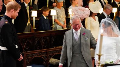 Britain's Prince Harry looks at his bride, Meghan Markle, as she arrives accompanied by the Prince Charles during the wedding ceremony of Prince Harry and Meghan Markle at St. George's Chapel in Windsor Castle in Windsor, near London, England, Saturday, May 19, 2018