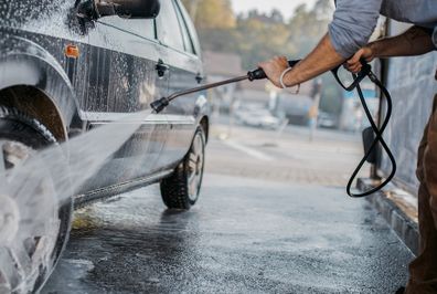 man washing car with hose