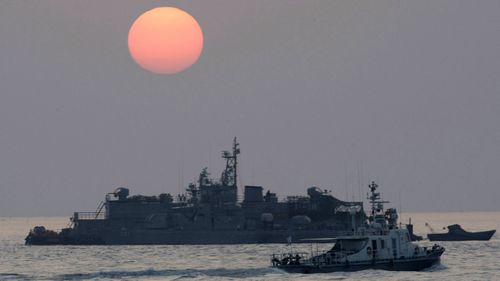 A government ship sails past the South Korean Navy's floating base as the sun rises near Yeonpyeong island, South Korea.