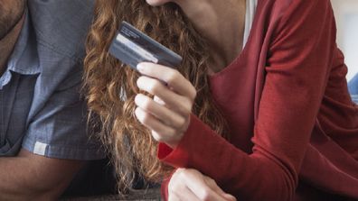 Couple doing their budget holding credit card