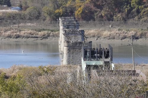 2022 年 11 月 4 日，星期五，一名游客在韩国坡州一座在朝鲜战争期间被毁的桥梁附近游览。  