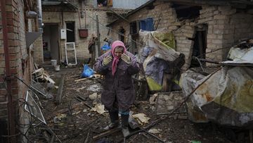 A woman is overwhelmed by emotion in a house damaged by a Russian airstrike in Gorenka, outside Kyiv.