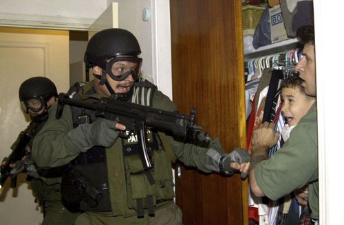 Alan Diaz captured the moment a US immigration agent burst into a Miami home and pointed a gun at six-year-old Cuban boy Elian Gonzalez. Picture: Alan Diaz/AP