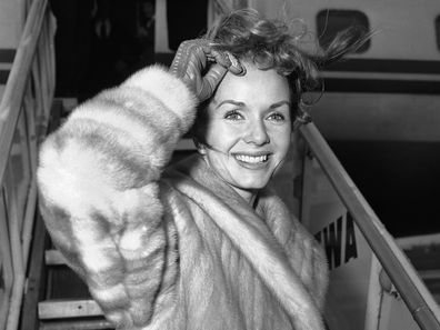 Screen actress Debbie Reynolds is a pretty wind-blown portrait as she boards airliner on March 6, 1959 in New York for Spain where she will film a new picture. She had flown in from California earlier in the day and contended with many questions about her divorced husband Eddie Fisher?s romance with Elizabeth Taylor. Said she: ?I wish them all happiness. That?s what we all want isn?t it?? (AP Photo/John Rooney)