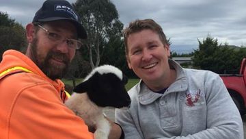Ralph the lamb was found by construction worker Nigel (left), and returned to owner Justin (right). (Victoria Police)