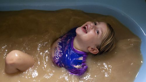 This is what the tap water looks like in Louth. Four-year-old Talita Cohen is pictured in a bath filled with the town's water.