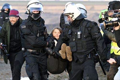 Police officers carry Swedish climate activist Greta Thunberg away from the edge of the Garzweiler II opencast lignite mine during a protest action by climate activists after the clearance of Luetzerath, Germany, Tuesday, Jan. 17, 2023.  
