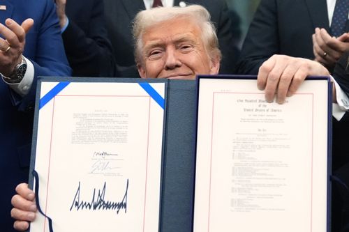 President Donald Trump displays the signed the funding bill to reopen the government, in the Oval Office of the White House, Wednesday, Nov. 12, 2025, in Washington.  