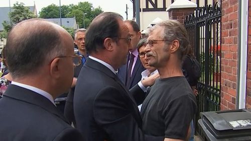 Francois Hollande comforts a local man after arriving at the scene of the Normandy terror attack. (AAP)