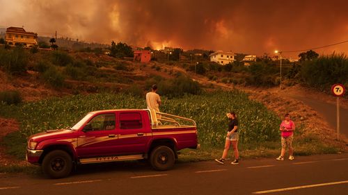 Local residents try to reach their houses in Benijos village as fire advances in La Orotava in Tenerife, Canary Islands, Spain.