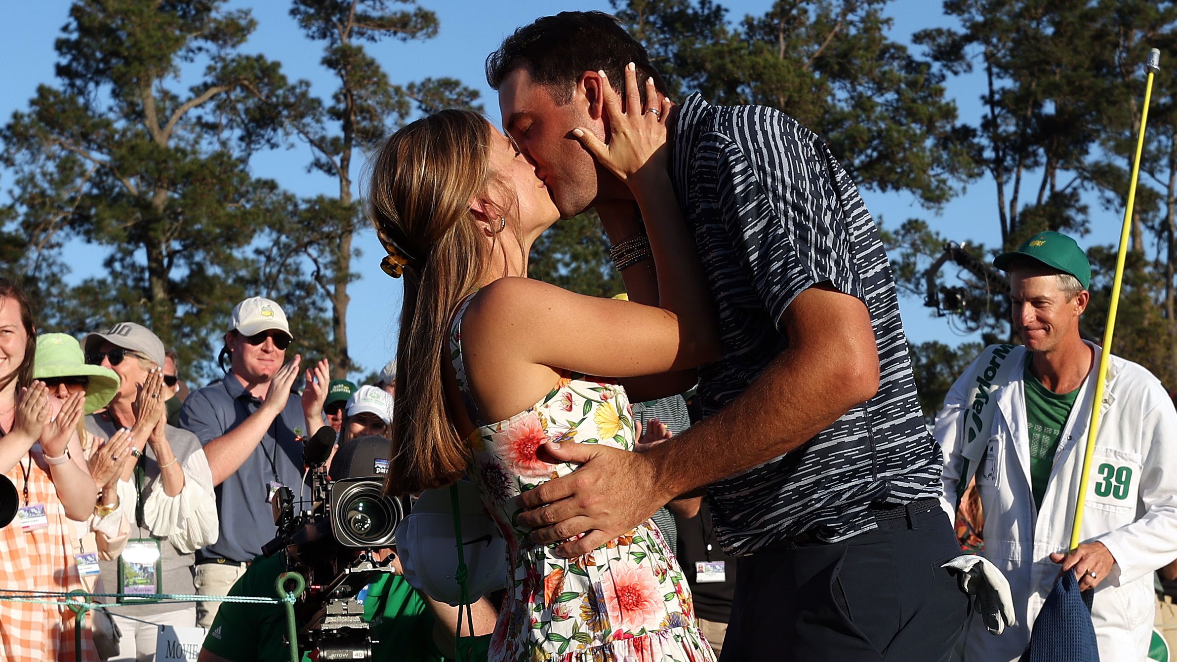 Scottie Scheffler and wife Meredith celebrate on the 18th green after Scheffler won the Masters at Augusta National Golf Club.