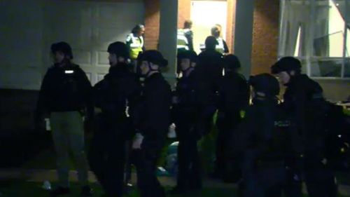 Police dressed in riot gear brought in the dog squad to assist. (9NEWS)