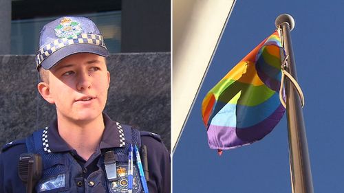 Constable Mairead Devlin, and the LGBTI flag outside the Brisbane police headquarters. (9NEWS)