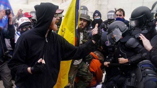 Violent protesters confront Capitol Police outside the Congress building.