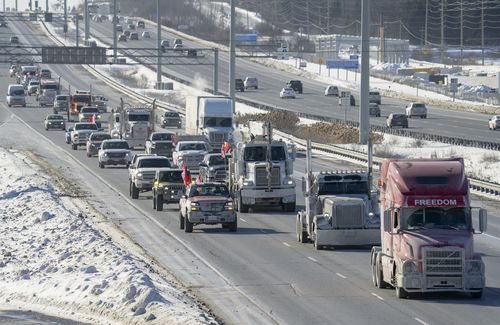 A trucker convoy driving to Parliament Hill in Ottawa to participate in a cross-country truck convoy protesting measures taken by authorities to curb the spread of COVID-19 and vaccine mandates makes it's way on the highway near Kanata, Ontario, Canada, on Saturday, Jan. 29, 2022. 