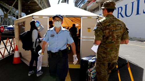 Crew members of the Ruby Princess cruise ship leave the vessel which has been docked at Port Kembla for more than two weeks following a catastrophic COVID-19 outbreak