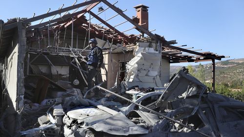 A journalist observes the site where an Israeli airstrike hit a compound housing journalists, killing three media staffers from two different news agencies according to Lebanon's state-run National News Agency, in Hasbaya village, southeast Lebanon, Friday, Oct. 25, 2024. (AP Photo/Mohammed Zaatari)