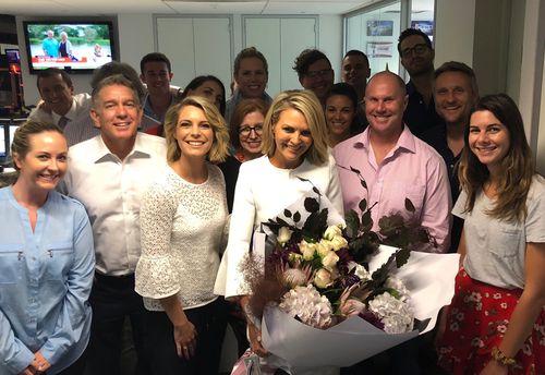 Georgie Gardner this evening with friends and colleagues at Nine News - and a large bunch of flowers.