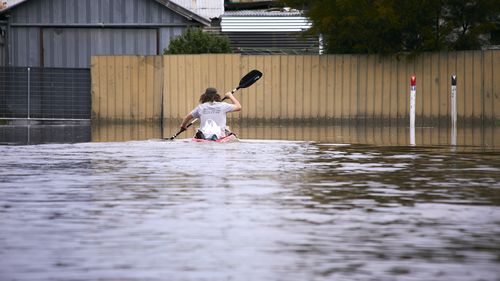 Bodi Fitzsimmons in kayak per strada durante le inondazioni a Shepparton, Victoria.
