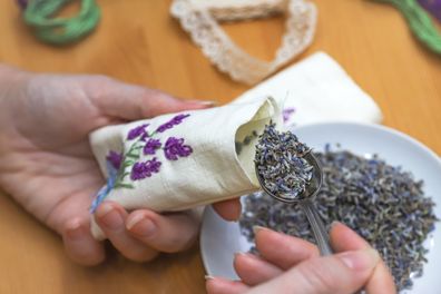 Making lavender sachet with floral embroidery at home on wooden background. Zero waste DIY gift. Homemade aromatherapy.