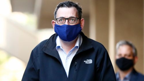 Victorian Premier Daniel Andrews wears a mask as he walks to his daily coronavirus briefing on Sunday.