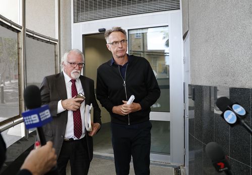 Former Olympic swimmer Neil Brooks walks out with his lawyer Chris Hannay from the Watchhouse after being granted bail yesterday. (AAP)