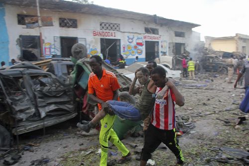 Somalis carry away a man injured after a car bomb was detonated in Mogadishu. (AP)