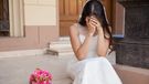 Hopeless bride crying outside a church after being stood up on her wedding day