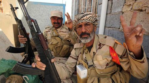 Iraqi pro-government fighters flash the sign for victory as they take part in an operation in al-Shahabi village, east of Fallujah, to retake the city from IS. (AFP)