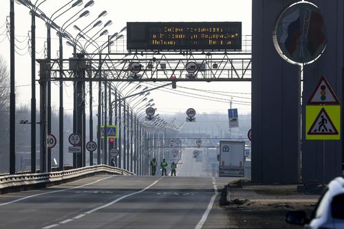 Road police stand at an empty highway to Russia at the Belarus-Russia border near Redki.