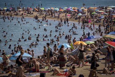 People cool off in the water on a hot and sunny day at the beach in Barcelona, Spain, July 15, 2022. 