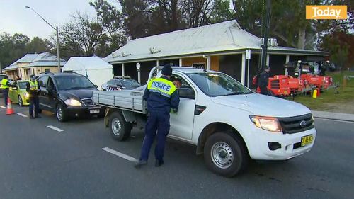 Police stop cars at the NSW-Victoria border.