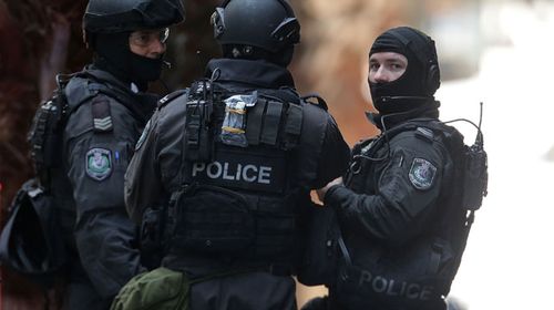 Armed officers talk on Phillip St close to Martin Place. (Getty)