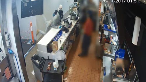 One of the armed men rushes the counter to scare staff (Supplied)
