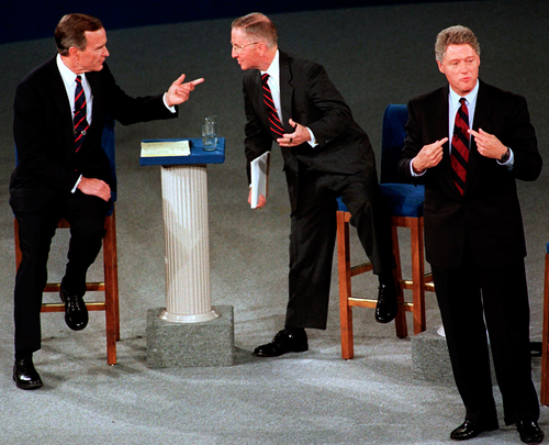 In this 1992 file photo, President George H.W. Bush, left, talks with independent candidate Ross Perot as Democratic candidate Bill Clinton stands aside at the end of their second presidential debate in Richmond.