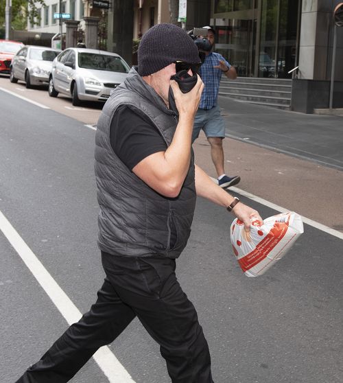 Workplace bullying claimant David Hingst covers his face as he leaves the Court of Appeal in Melbourne today.