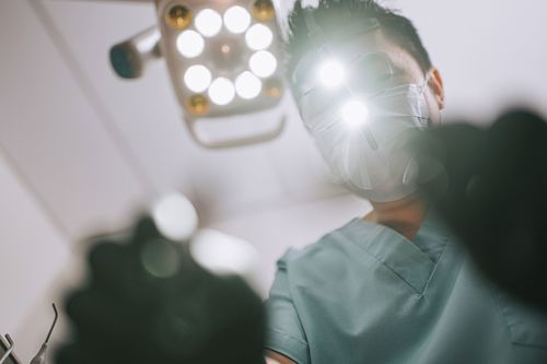 Dentist looks down on patient.