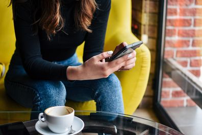 Woman using phone in cafe