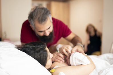 Newborn baby with her young parents